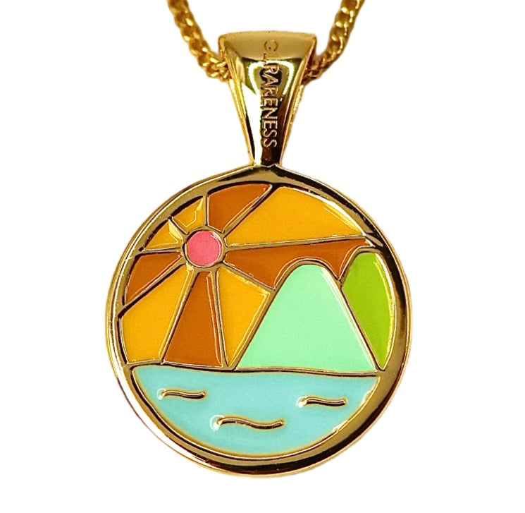 round gold medallion pendant necklace with cloisonné-style 7-color enamel landscape scene depicting radiating sun rays in orange and yellow with pink center, two geometric mountain peaks in mint and lime green, and light blue ocean with gold wave details, hung on gold curb chain, RARENESS branded bail, shown on white background and worn at collarbone
