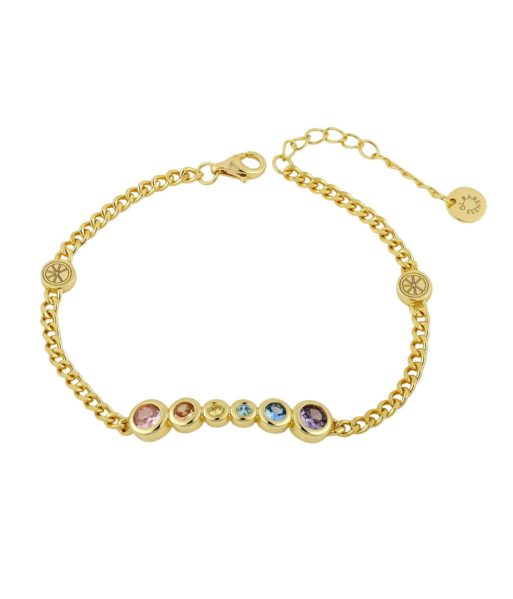 gold bracelet with six bezel-set cubic zirconia stones in pink peach yellow aqua blue and purple arranged in graduated sizes from large to small to large, flat curb chain, two brand logo medallions flanking the stone bar
